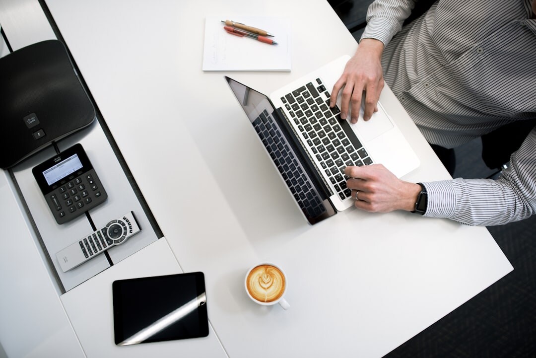 Journalist working at a newsroom desk with a laptop