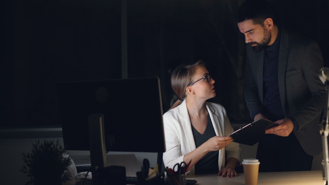 Two colleagues reviewing documents together in an office