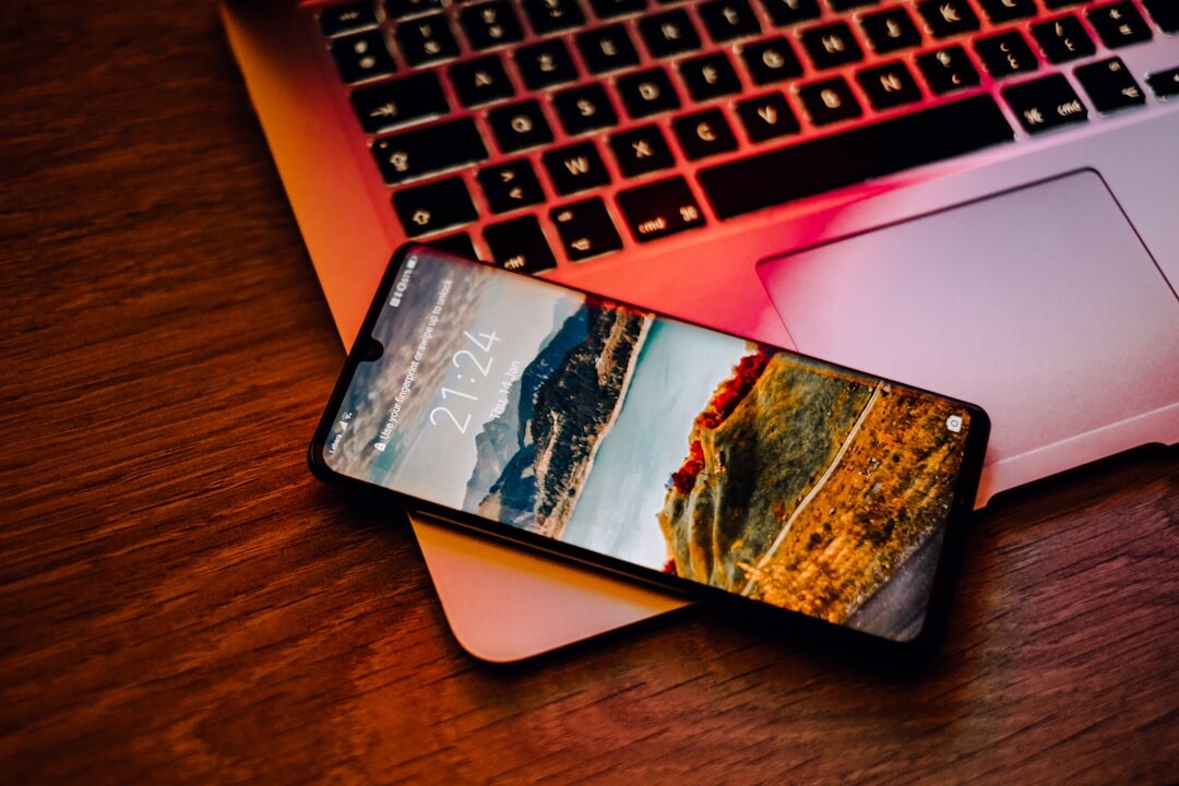 Open laptop and phone on a bright desk